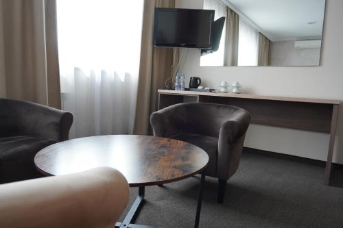 a room with a table and two chairs and a mirror at Noclegi-Restauracja Boss in Mogilno
