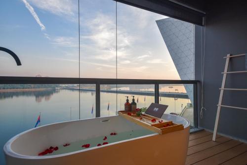 a bath tub in a room with a large window at R&F Princess Cove by Nest Home at Johor Bahru in Johor Bahru