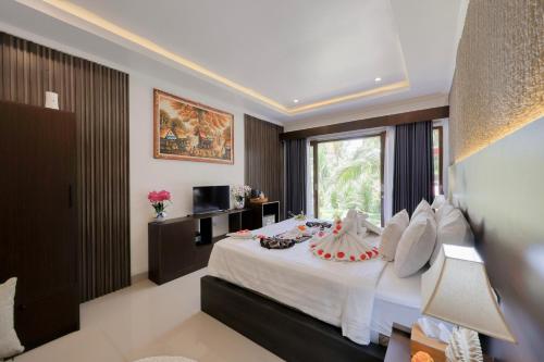 a bedroom with a large bed and a window at Kelingking Tropical in batumadeg