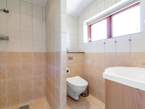 a bathroom with a toilet and a sink at Holiday Home Heilgard - 500m from the sea by Interhome in Hjørring