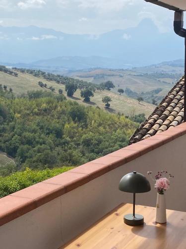 a table with a lamp on a balcony with a view at Casa Amrita B&B in Teramo