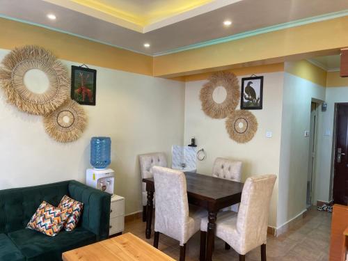 comedor con sofá verde y mesa en Splendid suites, en Syokimau