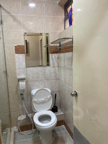 a bathroom with a toilet with a shower and a mirror at Splendid suites in Syokimau