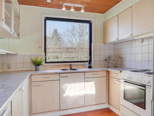 a kitchen with white cabinets and a window at Holiday Home Ludde - 500m to the inlet by Interhome in Løgstør