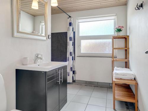 a bathroom with a sink and a mirror at Holiday Home Swipdagh - 600m from the sea by Interhome in Fjerritslev