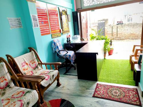 een kamer met stoelen en een bureau met een groen kleed bij Akshayavat Palace in Ayodhya