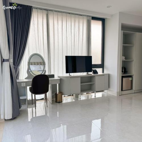 a room with a desk with a television and a chair at Greenlife Village Phú Quốc in Phu Quoc