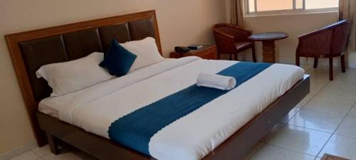 a bedroom with a large bed with blue and white sheets at Hotel Oasis in Morogoro