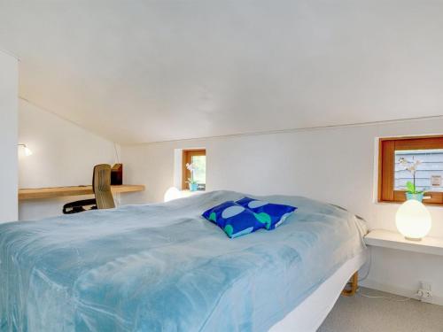 a bedroom with a large bed with blue sheets at Holiday Home Grubbe - 600m from the sea by Interhome in Hjørring