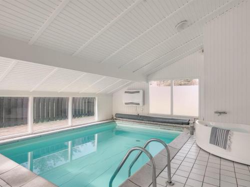 a large swimming pool with a tub and a bath tub at Holiday Home Franka - 950m from the sea by Interhome in Hjørring