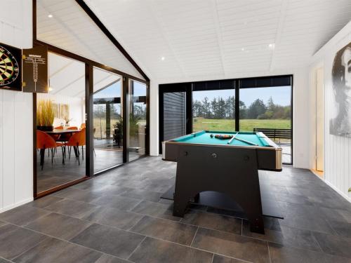 a pool table in a living room with glass doors at Holiday Home Sasja - 1-5km from the sea by Interhome in Hjørring