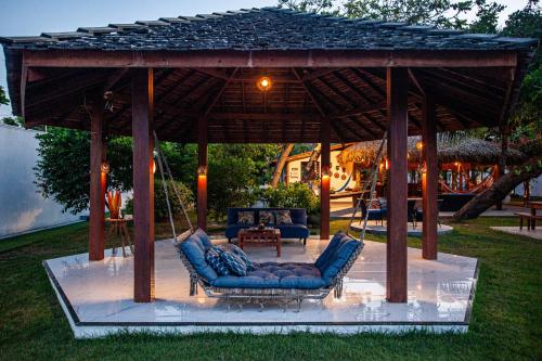 a gazebo with blue chairs and a swing at Hotel de Charme Illuminare Stile in Fortim