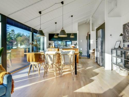 a kitchen and dining room with a table and chairs at Holiday Home Remko - 1-5km from the sea by Interhome in Hjørring