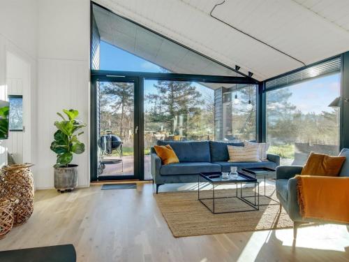 a living room with a blue couch and a table at Holiday Home Remko - 1-5km from the sea by Interhome in Hjørring