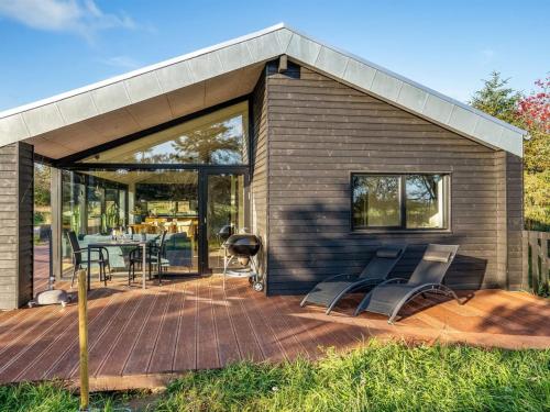 a small house with a deck and a patio at Holiday Home Remko - 1-5km from the sea by Interhome in Hjørring