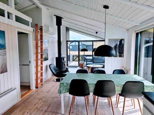 ein Esszimmer mit Tisch und Stühlen in der Unterkunft Holiday Home Auvo - 600m from the sea by Interhome in Hjørring