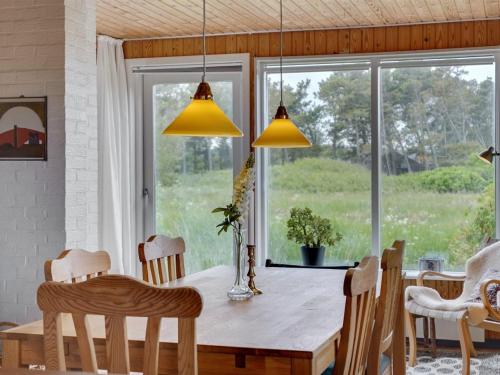 a dining room with a table and chairs and a window at Holiday Home Øgrim - 204m from the sea by Interhome in Hirtshals