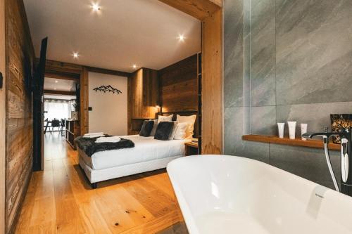 a bedroom with a bed and a bath tub at CHALET TEKA LES GETS - Appartement Adret in Les Gets