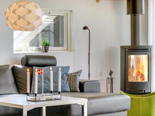 a living room with a couch and a table with candles at Holiday Home Aria - 1-2km from the sea by Interhome in Hirtshals