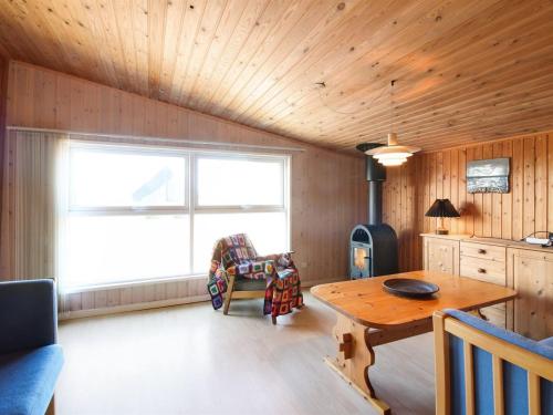 a living room with a wooden ceiling and a table at Holiday Home Nea - 234m from the sea by Interhome in Hirtshals