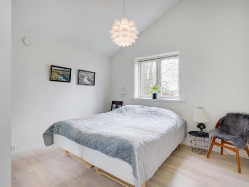 a white bedroom with a bed and a window at Holiday Home Skammel - 900m from the sea by Interhome in Bindslev