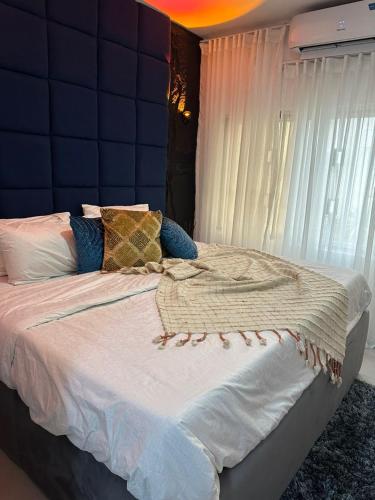 a bedroom with a large bed with a blue wall at Royal tamah concept in Ikate