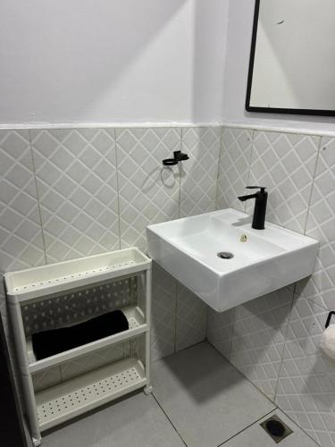 a white bathroom with a sink and a mirror at Royal tamah concept in Ikate