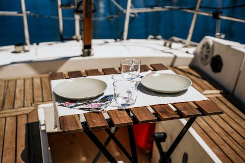 a table with two plates and glasses on a boat at The Classic Sailboat Retreat in Lisbon