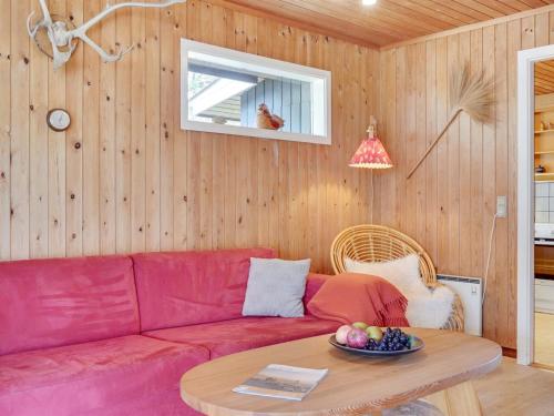 a living room with a red couch and a table at Holiday Home Asmara - 200m from the sea by Interhome in Læsø