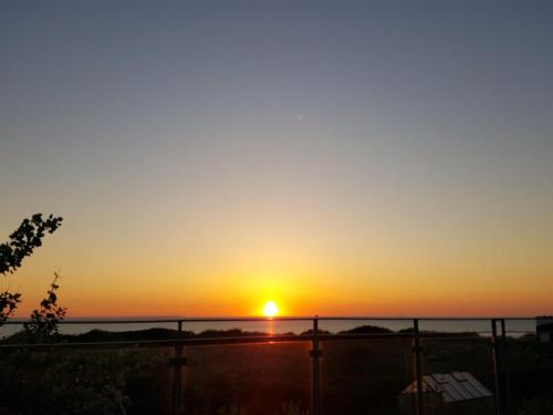 a sunset from the balcony of a house at Holiday Home Brun - 60m from the sea by Interhome in Læsø