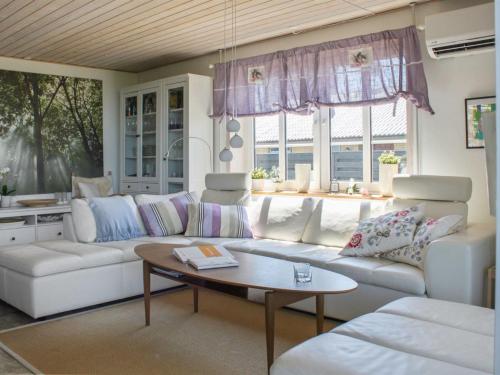 a living room with a white couch and a table at Holiday Home Brun - 60m from the sea by Interhome in Læsø