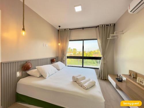 a bedroom with a large bed with towels on it at Bella Arte 2 Rooftop in Aquiraz