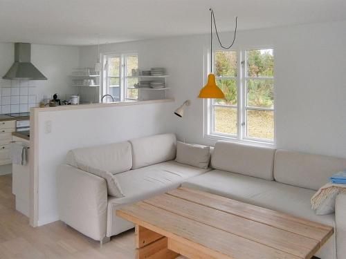a living room with a white couch and a table at Holiday Home Siggi - 400m from the sea by Interhome in Jerup