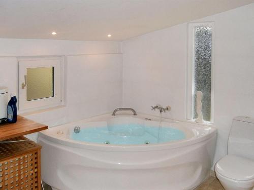 a bath tub in a bathroom with a toilet at Holiday Home Siggi - 400m from the sea by Interhome in Jerup
