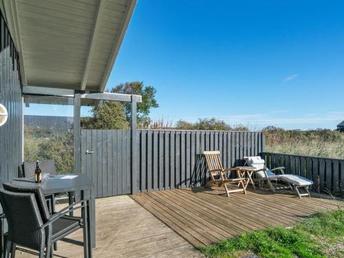 a wooden deck with a table and chairs on it at Holiday Home Bothilda - 660m from the sea by Interhome in Bindslev