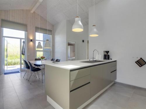 a white kitchen with a sink and a table at Holiday Home Grith - 1km from the sea by Interhome in Hirtshals