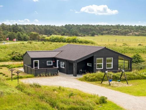 a black house in the middle of a field at Holiday Home Grith - 1km from the sea by Interhome in Hirtshals