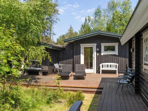 a deck with chairs and a bench on a house at Holiday Home Ascen - 300m from the sea by Interhome in Læsø