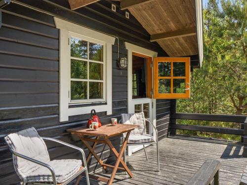 a patio with chairs and a wooden table on a house at Holiday Home Ascen - 300m from the sea by Interhome in Læsø