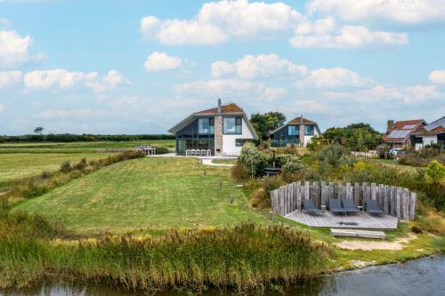 a house on an island in the middle of a river at Natuurvilla 16 Weegeswaal in De Waal