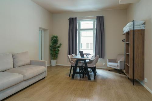 a living room with a couch and a table with a laptop at MAYA Apartments - Parkveien in Oslo