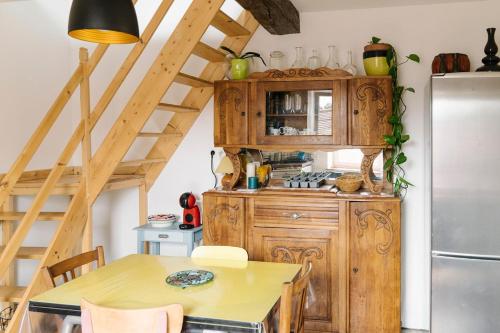 a kitchen with wooden cabinets and a table and a refrigerator at Maison de charme, quartier thermal in Bourbon-Lancy