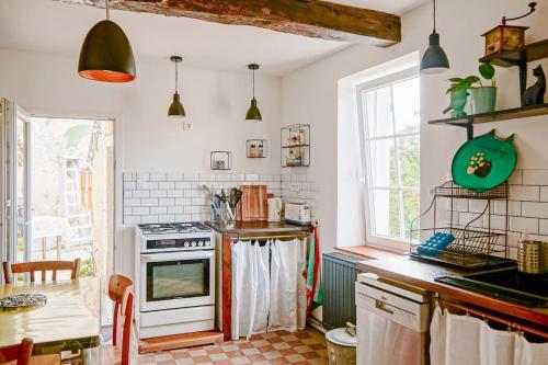 a kitchen with white walls and a stove top oven at Maison de charme, quartier thermal in Bourbon-Lancy