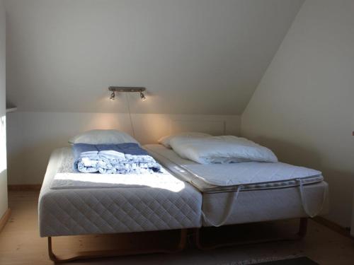 a twin bed in a room with a roof at Holiday Home Tara - 300m from the sea by Interhome in Læsø
