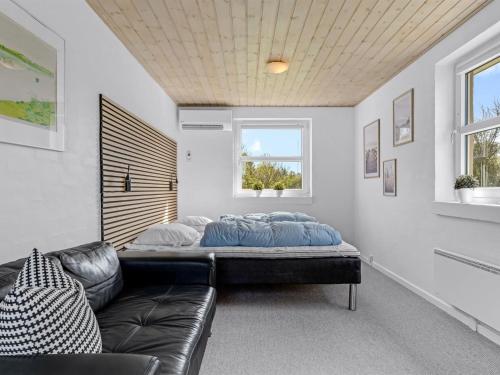 a room with a bed and a couch and a window at Holiday Home Albina - 844m from the sea by Interhome in Hjørring
