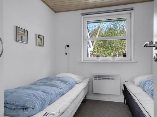 a bedroom with a bed and a window at Holiday Home Albina - 844m from the sea by Interhome in Hjørring