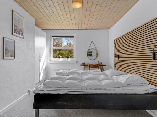 a large bed in a room with a window at Holiday Home Albina - 844m from the sea by Interhome in Hjørring
