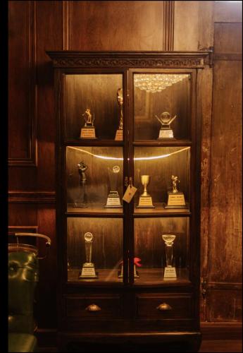 a display cabinet with trophies in a room at Palm Villa - Award Winning Modern Luxury & Exclusive Villa in Chiang Mai