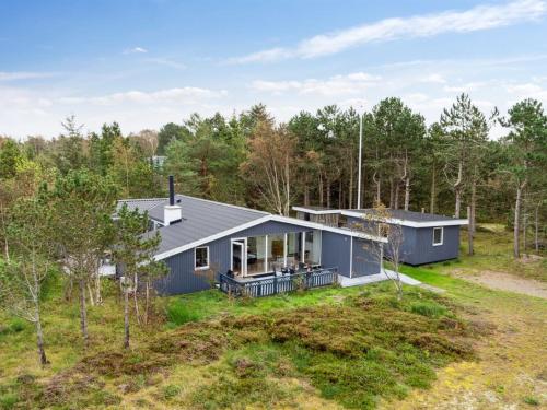 a blue house in the middle of the forest at Holiday Home Djuna - 200m from the sea by Interhome in Læsø