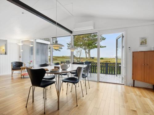 a kitchen and dining room with a table and chairs at Holiday Home Djuna - 200m from the sea by Interhome in Læsø